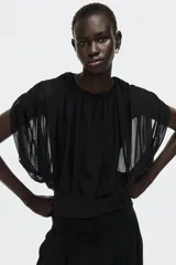 Body colaless negro con diseño drapeado y top de malla superpuesto de mangas cortas y escote redondo.