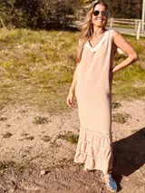 Vestido largo color rosa pálido, confeccionado en polilino y algodón, con escote en V y volados en ruedo y mangas.