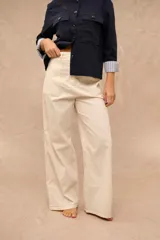 Pantalón de corte ancho, color crudo, con bolsillos delanteros aplicados y costuras pespunteadas a contratono.