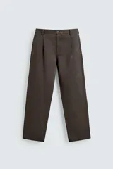 Pantalón de corte relaxed fit confeccionado en tejido de mezcla de algodón y lino. Presenta cintura con pliegues frontales, bolsillos laterales y bolsillos traseros de doble vivo. Cierre frontal con cremallera y botón.