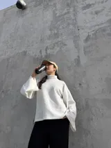 Polerón de cuello alto en color blanco, con diseño de calce holgado y mangas amplias. Confeccionado en tela suave y abrigada, ideal para un estilo urbano y relajado.