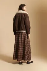 Falda larga de corte amplio y fluido con estampado de cuadros en tonos tierra. Presenta un diseño de tiro medio que aporta elegancia y comodidad.