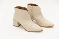 Botín de cuero negro con textura croco, punta fina y taco cuadrado de 6 cm.