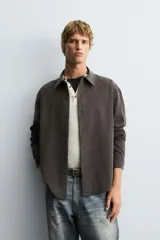 Camisa de corte relajado confeccionada en tejido fluido con mezcla de lyocell. Presenta cuello solapa, manga larga, cierre frontal con botones y un acabado con efecto lavado.