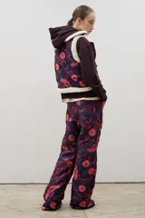 Pantalón de tiro alto y corte recto, confeccionado en tela brocato con estampado floral y de aves en tonos azul marino y rosado.