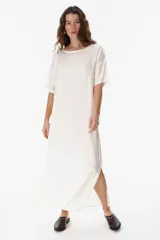 Vestido estilo remerón de corte holgado y largo midi, confeccionado en tejido liviano y suave. Presenta cuello redondo, mangas cortas y tajos laterales en el ruedo.