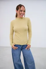 Polerita de manga larga color pistacho, con cuello alto y bordes ondulados en cuello, puños y dobladillo.