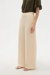 Pantalón de viscosa color beige, de corte ancho, tiro alto y diseño fluido.