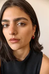 Aros dorados con dije circular de piedra natural negra.