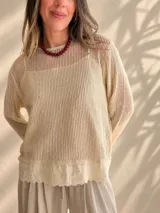 Sweater de punto calado color rosado, con diseño holgado, cuello redondo y mangas largas, que incluye una musculosa interior con terminación bordada en el bajo.