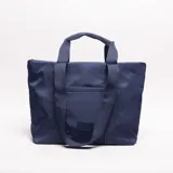 Bolso tipo tote bag de nylon azul marino, con asas de cinta tejida y bolsillo frontal exterior.