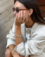 Pulsera de diseño artesanal elaborada eslabón por eslabón a mano, con eslabones circulares texturados de metal dorado y cadena regulable.
