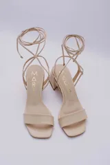 Sandalias negras de cuero con tacón cuadrado y tiras finas para atar al tobillo.