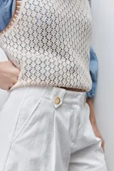 Short de tiro alto confeccionado en algodón, con calce relajado y silueta recta. Presenta pinzas delanteras, bolsillos laterales y botones decorativos en la cintura.
