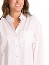 Camisa de corte oversize marca Grand & Greene, confeccionada en una mezcla de tencel, poliéster y elastano. Presenta cuello con solapa, cierre frontal con botones, mangas largas con hombros caídos y puños con botón. Incluye un bolsillo en el pecho, canesú trasero con tablón central y un bajo redondeado asimétrico, siendo más largo en la parte posterior.