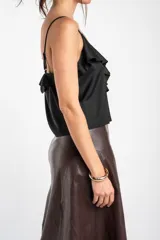 Musculosa negra de satén con escote en V, tirantes finos y detalle de volados en el pecho.