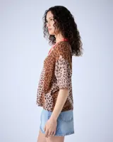 Polo de cashmere con estampado animal, corte oversize, mangas cortas, cuello escote en V, cierre de botón y bordes acanalados.