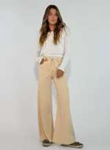 Pantalon de corte recto y tiro medio, confeccionado en gabardina color marrón. Presenta cierre frontal con botón y bolsillos laterales.