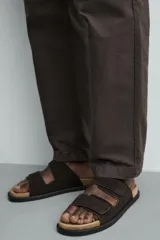 Sandalias de piel de acabado serraje en color marrón, con dos tiras anchas ajustables con cierre adherente en el empeine, plantilla anatómica y suela plana.