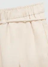 Pantalon de corte recto y diseño fluido, confeccionado en una mezcla de lyocell y viscosa. Presenta cintura elástica con cordón ajustable, bolsillos laterales y un acabado texturizado.