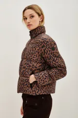 Campera puffer de corte corto con estampado animal print. Cuenta con cierre frontal, cuello alto y bolsillos laterales con cierre.