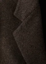 Blazer de corte recto confeccionado en tejido mezcla de lana con diseño jaspeado. Presenta cuello con solapas de muesca, cierre frontal con botones, dos bolsillos de parche delanteros, mangas largas con puños abotonados y abertura posterior en el bajo. Incluye forro interior.