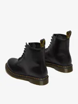 Botas de caña media Dr. Martens modelo 1460, color negro, con cierre de cordones de 8 ojales, costuras amarillas distintivas en la suela y lengüeta trasera con logo.