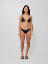 Top de bikini Rusty modelo Melina, color negro, con diseño triangular y tirantes finos ajustables.