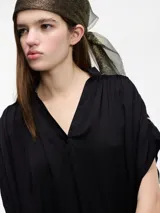 Blusa color crema de manga corta con bordados en la parte trasera.