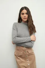 Polera gris de manga larga y cuello alto, confeccionada en tejido suave y ligero.