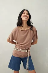 Remera negra de manga corta, confeccionada en modal, con cuello bote y frunces laterales.