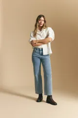 Jean de corte recto y tiro medio, confeccionado en denim elastizado. Presenta un diseño clásico con terminación de botamanga desflecada.