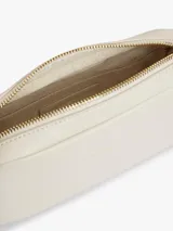 Cartera tipo bandolera de diseño compacto y líneas redondeadas, marca Tommy Hilfiger. Está confeccionada en poliuretano con acabado liso de color beige, cierre de cremallera y cuenta con una inscripción de la marca en bajo relieve en la parte delantera. Incluye una correa cruzada ajustable de jacquard tonal con el logo de la marca.