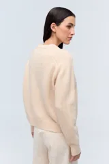 Sweater crudo de lana con cuello redondo y mangas raglán.