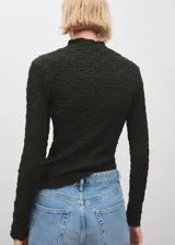 Top de crepé con textura, color verde oscuro, diseño entallado, cuello festoneado y manga larga.