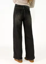 Pantalon recto bicolor con frente en denim azul y espalda en denim negro, presenta franjas laterales en tono claro y cierre frontal con botones.