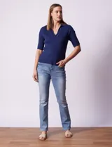 Buzo azul de tejido acanalado, con cuello solapa y escote en V en tejido calado.