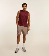 Bermuda deportiva para hombre, color beige, con cintura elástica y cordón ajustable. Cuenta con bolsillos con cremallera, recortes laterales con agujeros y aberturas en el bajo.