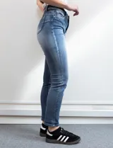 Jean skinny de denim azul con efecto lavado. Pretina con pasadores, botón y cierre. Delantera y trasera con bolsillos.