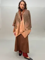 Ruana de lana merino tejida, teñida y estampada, con cuello plisado en fieltro de lana merino.