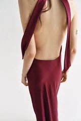 Vestido largo satinado de color bordó, con cuello halter fruncido y diseño sin mangas.