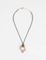 Collar de cordón negro con dije metálico en forma de flor irregular con centro calado.