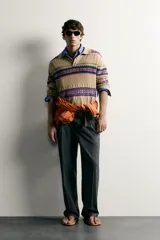 Sweater de punto jacquard de algodón y lino, color tostado con diseño de franjas geométricas en tonos violeta, fucsia y verde. Presenta cuello polo con cierre frontal de tres botones, mangas largas y puños y cintura en rib.
