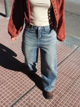 Pantalón de jean azul con diseño de rayas verticales finas, corte holgado y tiro medio.