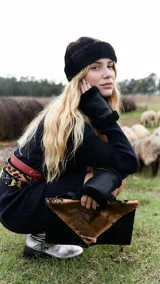 Sobre de cuero color rojo y negro con diseño de vaca y cierre con botón de guampa.