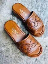Sandalias de cuero color marrón tostado, con taco chino bajo y capellada ancha decorada con diseño geométrico grabado.