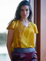 Blusa color naranja de gasa pintada con cuello asimétrico y mangas cortas.