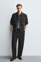 Bota estilo Chelsea de cuero negro, con elásticos laterales y suela plana a tono con ligero tacón.