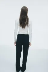 Jean de corte recto y tiro alto confeccionado en denim rígido de cinco bolsillos. Presenta un diseño de pierna recta levemente holgada y cierre frontal con botón.