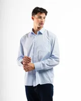 Camisa de vestir de corte clásico y manga larga, en color celeste claro. Presenta cuello camisero, cierre frontal con botones y un bolsillo abierto en el lado izquierdo del pecho.